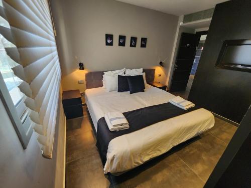Schlafzimmer mit einem Bett mit weißer Bettwäsche und Kissen in der Unterkunft YalaRent Haven villa with private pool and jacuzzi in Eilat