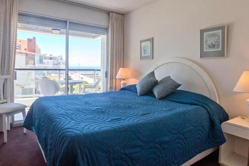 1 dormitorio con cama y ventana grande en Oceana Suites en Terrazas del Faro, vista al mar, en Punta del Este