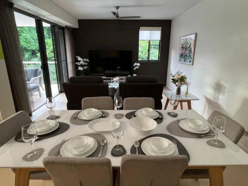 einen Esstisch mit Tellern und Weingläsern in der Unterkunft Luxury Waterfront Apartment (2 bedrooms) in Darwin