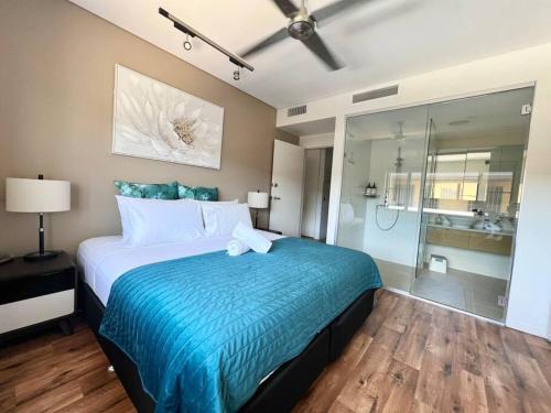 a bedroom with a large bed and a shower at Luxury Waterfront Apartment (2 bedrooms) in Darwin
