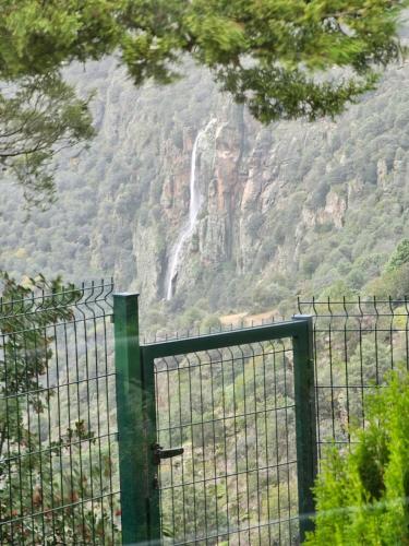 a gate in front of a waterfall in a mountain at Junção - Apartamentos Completos in Miranda do Douro