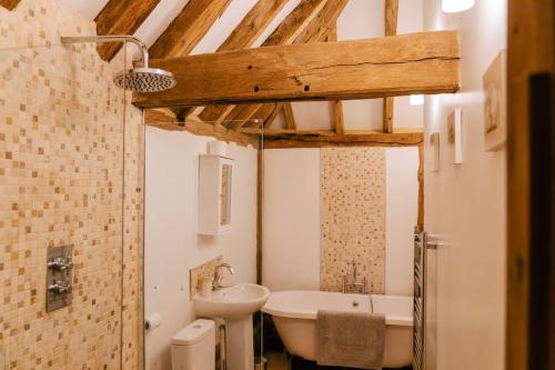 een badkamer met een wastafel, een bad en een toilet bij NEW Cosy cottage - Lake view & Log Burner - Dog proof garden in Rolvenden