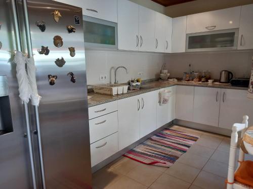 a kitchen with white cabinets and a stainless steel refrigerator at Casa da Montanha in Salão