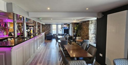 a restaurant with tables and chairs and a bar at The Birchtree Hotel in Dalbeattie
