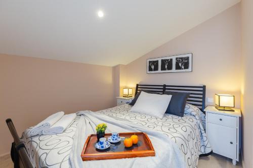 a bedroom with a bed with a tray of food on it at Marina Blue by Fidalsa in La Marina