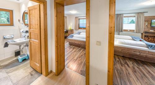 baño con 2 camas y lavabo en una habitación en Appartements Am Burgsee en Ladis