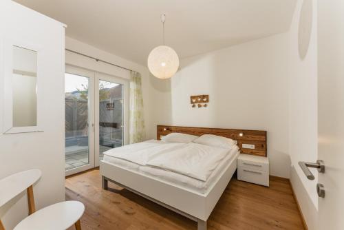 シュラートミンクにあるAppartement Gabbie by Schladming-Appartementsの白いベッドルーム(ベッド1台、窓付)