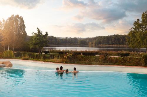 un groupe de trois personnes dans une piscine avec un lac dans l'établissement Center Parcs Le Lac d’Ailette, à Chamouille