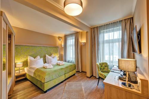 um quarto de hotel com uma cama e uma cadeira em SPREE Hotel in der Altstadt em Lübbenau