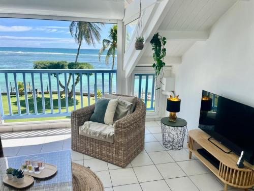 a living room with a view of the ocean at Ti MACLOA - Appartement les pieds dans l'eau in Sainte-Anne