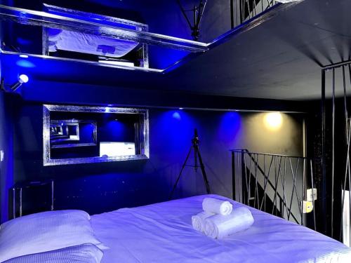 um quarto azul com uma cama com duas toalhas brancas em Love Room - Dayan 1 em Villeurbanne