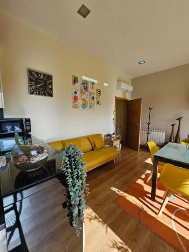 a living room with a yellow couch and a table at Junção - Apartamentos Completos in Miranda do Douro