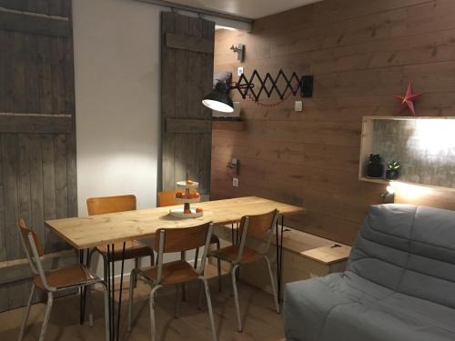 une salle à manger avec une table et des chaises en bois dans l'établissement Un petit nid au pied des pistes, à Bagnères-de-Bigorre
