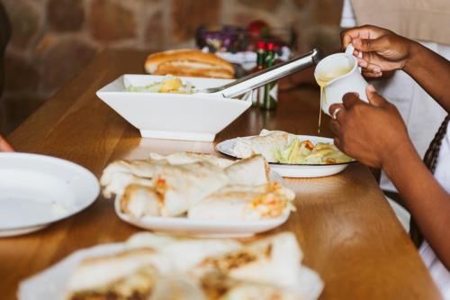 a group of people sitting at a table eating food at Matatane Camp - Babanango Game Reserve in Nkwalini