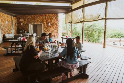 un grupo de personas sentadas en mesas en un restaurante en Matatane Camp - Babanango Game Reserve en Nkwalini