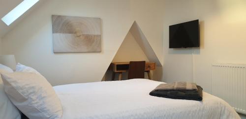 a bedroom with a bed and a tv on the wall at Comfort Stay Sussex 5-bed in Portslade
