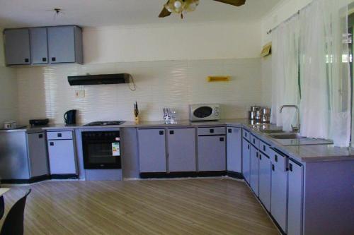 a large kitchen with blue cabinets and appliances at 2 bedroomed house with a lovely garden - 2177 in Umtali