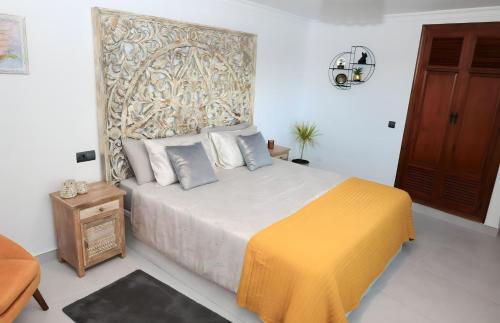 a bedroom with a bed with a yellow blanket at La Pina Verde in Estepona