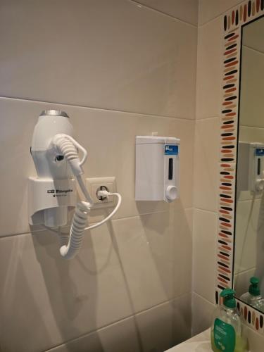 a bathroom with a white blow dryer on the wall at Junção - Apartamentos Completos in Miranda do Douro