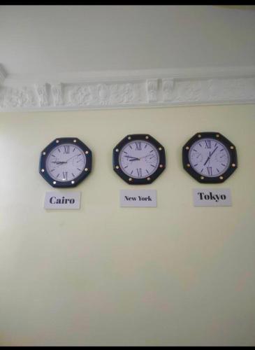 three clocks on a wall with different time zones at Matto Pyramids Inn in Cairo
