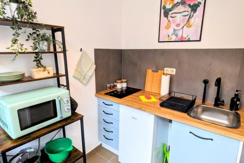 a small kitchen with a microwave and a counter at Uhlpartment - im Herzen von Salzwedel in Salzwedel