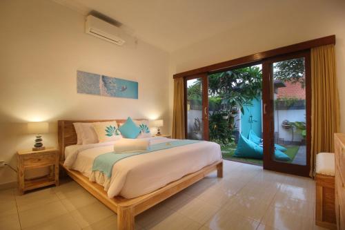 a bedroom with a bed and a large window at Villa Lotus Flower Sanur in Sanur