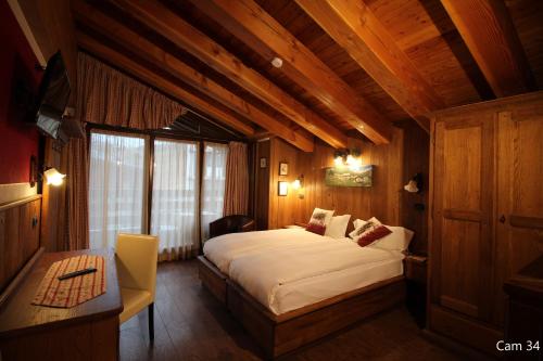 um quarto com uma cama grande num quarto de madeira em Hotel Meynet em Breuil-Cervinia