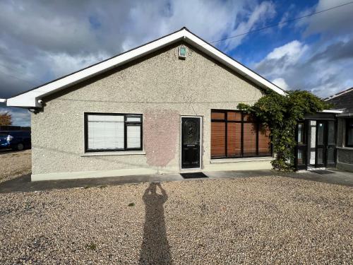 a shadow of a person standing in front of a house at Straffan in Straffan