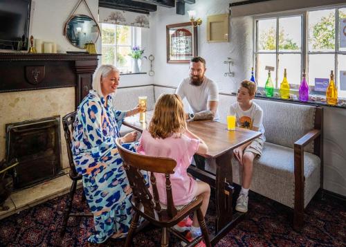 un grupo de personas sentadas alrededor de una mesa en White Rose Country Cottages en Thormanby