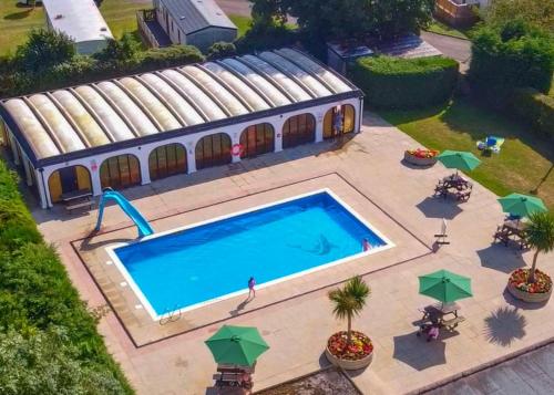 an overhead view of a swimming pool with a building at White Rose Country Cottages in Thormanby