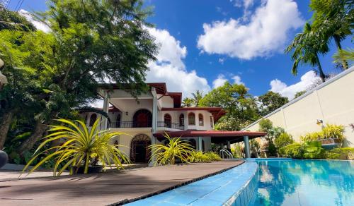 a house with a swimming pool in front of a house at Wisdom Boutique Resort in Kandy
