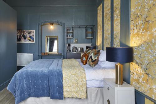 um quarto com uma cama e uma parede azul em 81 Promenade Studios em Cheltenham
