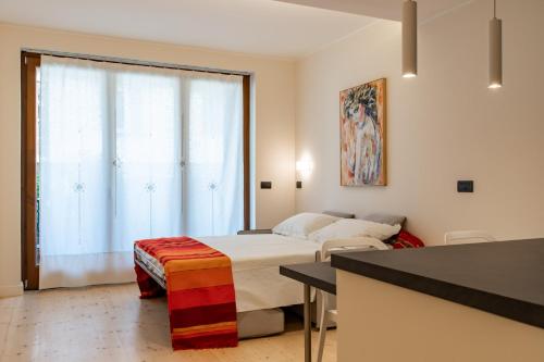 um quarto com uma cama e uma grande janela em Loft Marina em Fossano
