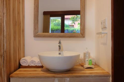 a bathroom with a bowl sink and a mirror at Villa Lotus Flower Sanur in Sanur