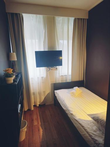 a bedroom with a bed with a television and a window at Lidingö Arena Hotel in Lidingö