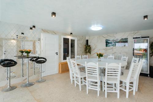 a dining room with a white table and white chairs at Casa Maramureșană Beliș in Beliş
