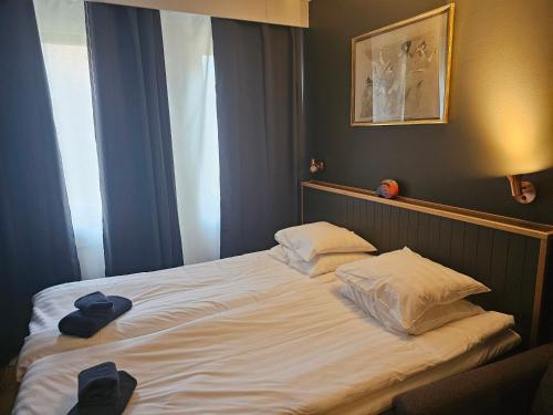 a large white bed with two pillows in a bedroom at Lidingö Arena Hotel in Lidingö
