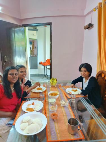 a group of women sitting at a table eating food at Bliss Homestay Munroe Island in Munroe Island
