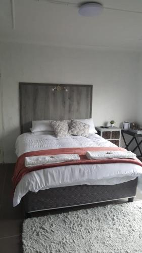 1 dormitorio con 1 cama grande y cabecero de madera en LARA'S PLACE en Volksrust