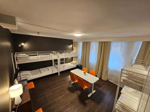 a room with bunk beds and a table and chairs at Lidingö Arena Hotel in Lidingö