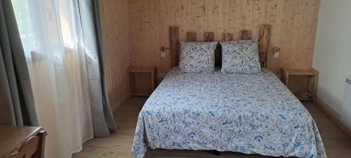 sypialnia z łóżkiem z niebieską kołdrą w obiekcie Gîte du Faraud w mieście Dévoluy