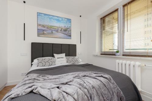 a bedroom with a large bed and a window at Warsaw City Life Apartment Bagno by Renters in Warsaw