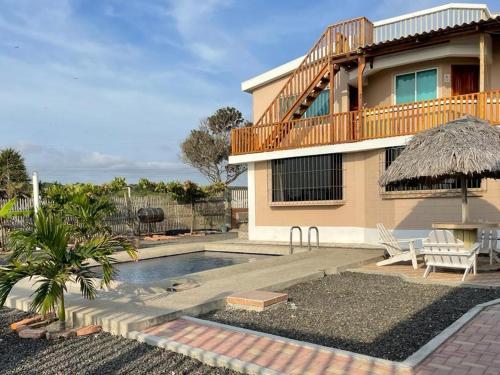 a house with a swimming pool next to a house at Hostal Cabañas Vistamar in Crucita