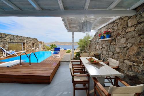 a patio with a table and chairs and a pool at Villa Princess 1 4Bed with Pool Panormos Beach in Panormos Mykonos