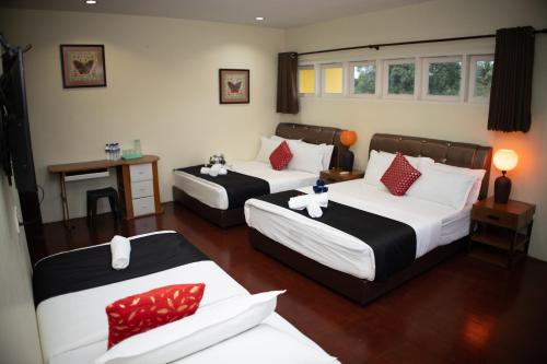 a hotel room with two beds and a table at Sweet Inn Guest House in Kuantan
