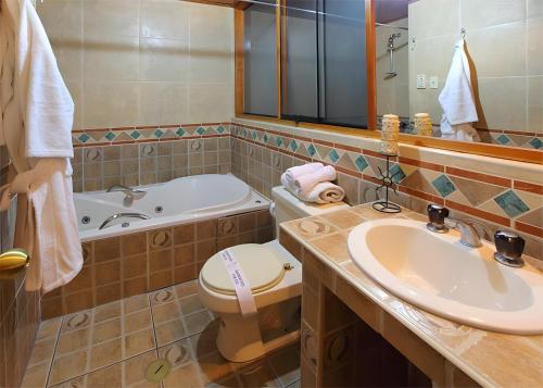 e bagno con lavandino, servizi igienici e vasca. di Hotel El Puma a Cuzco