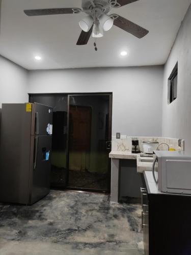 een keuken met een koelkast en een plafondventilator bij Kame house. in Coronado
