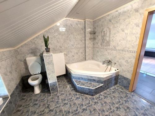 a bathroom with a bath tub and a toilet at Countryside Apartment Agnes in Šentjošt nad Horjulom