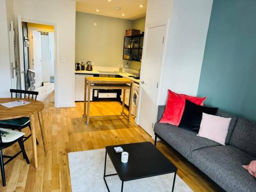 a living room with a couch and a table and a kitchen at Stylish city flat with private parking in Bristol