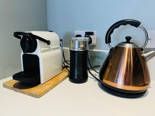 a tea kettle on a counter next to a toaster at Stylish city flat with private parking in Bristol